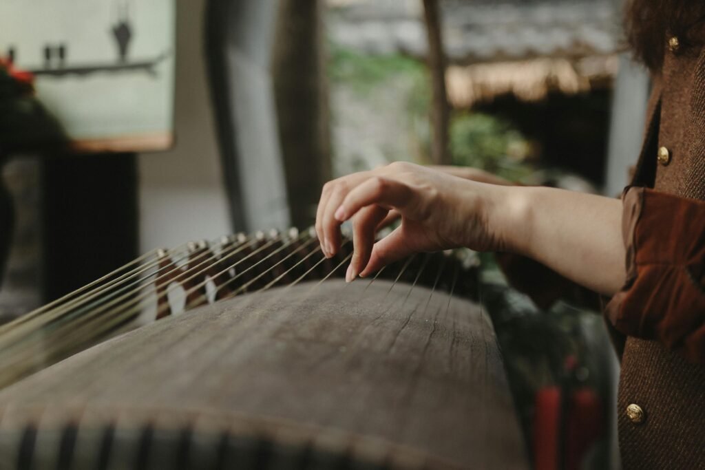 pexels-photo-29253120-29253120 Hands playing a Guzheng instrument, showcasing traditional music in an intimate setting.