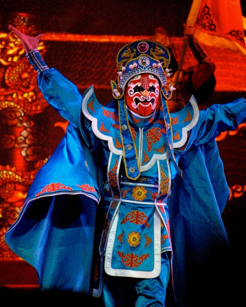 pexels-photo-7032138-7032138 Colorful Beijing opera performer showcasing traditional mask and costume during a festival.